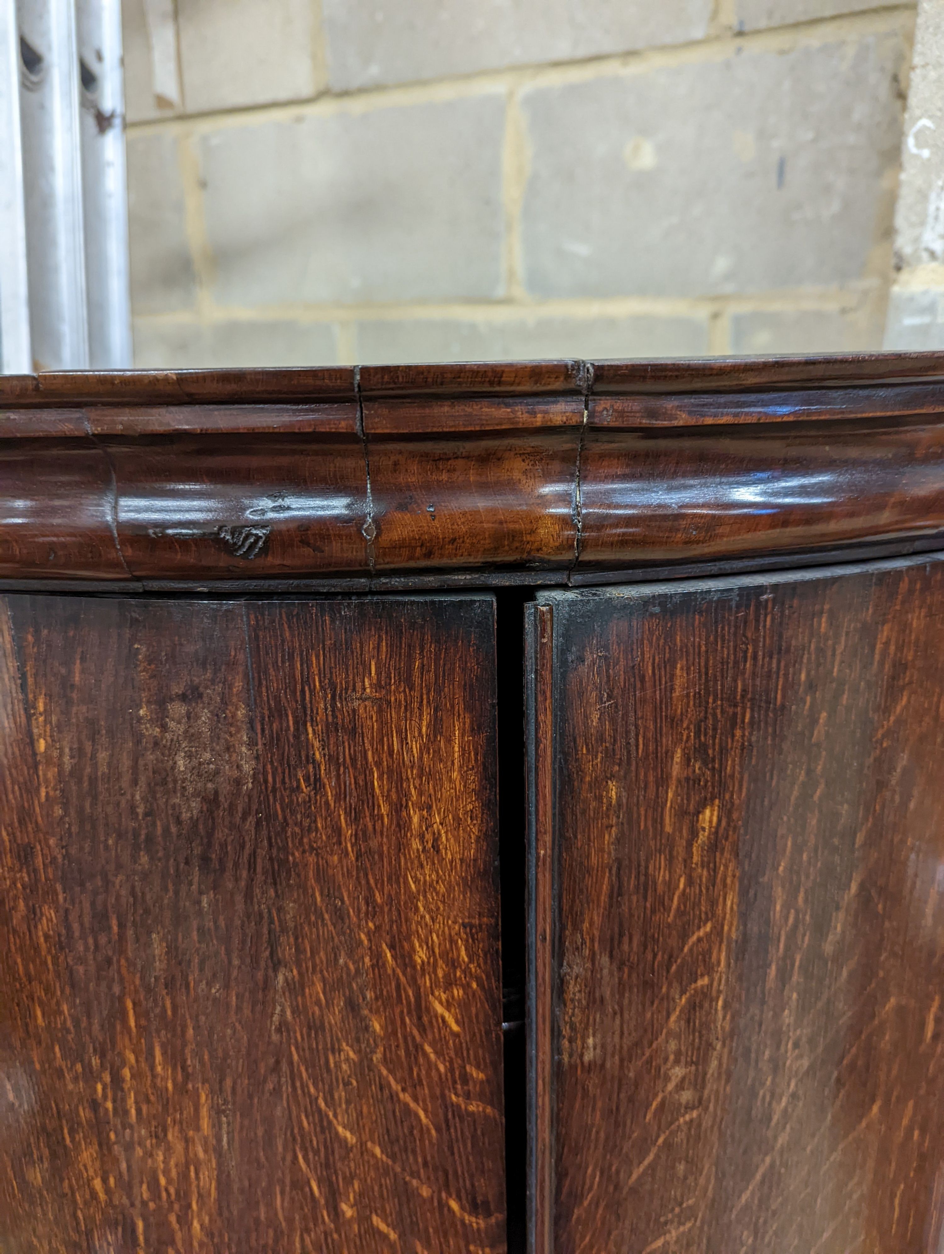 A George III oak bow-fronted hanging corner cabinet, width 73cm, depth 52cm, height 132cm